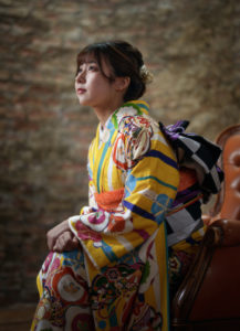 椅子に座った振袖を着た女性