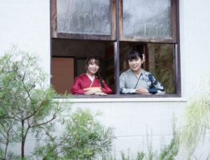 窓辺に立つ振袖を着た2人