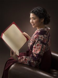 大学卒業証書を持った袴を着た女子